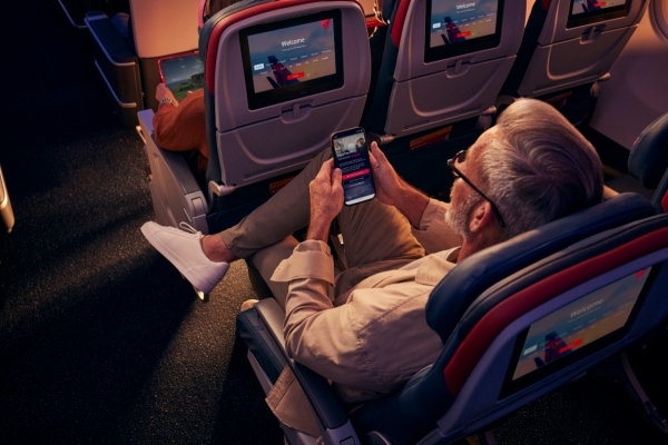 Man using phone and free wi-fi on aircraft