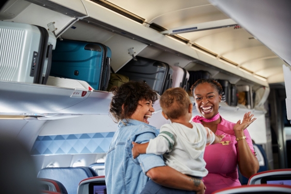 Flight attendant waiving to baby on airplane