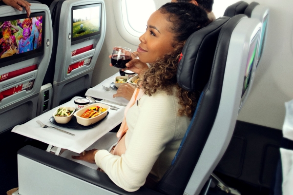 Woman seated in Delta Premium Select with meal