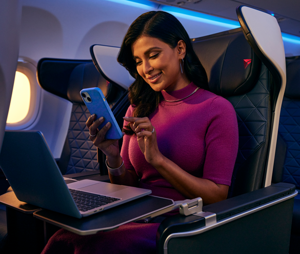 Cliente de Delta en First Class en un A321neo utilizando el Wi-Fi rápido y gratuito de la aerolínea en su smartphone