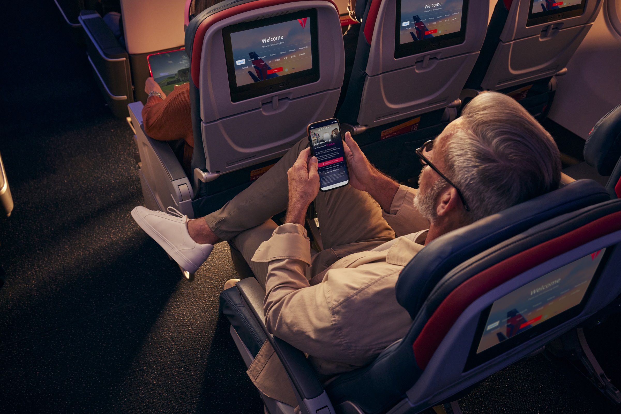 Man using phone and free wi-fi on aircraft